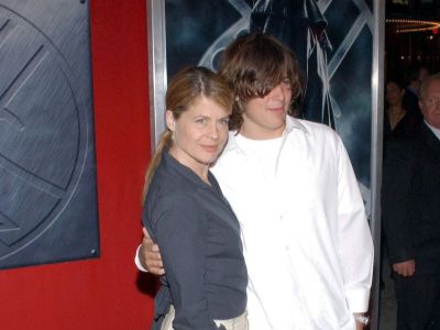 Linda Hamilton is wearing a grey shirt and Dalton Abbott is wearing a white shirt.